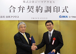 23日に日本アクセスの本社で合弁契約を結んだ田中茂治日本アクセス社長（左）と、儀間仁ジーマ社長