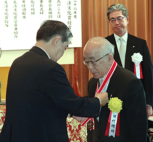 親子2代で特別功労賞を受賞し、記念メダルを授与される田村暉昭氏