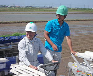 学生の介添えで新品種の田植えを行う泉田裕彦新潟県知事（左）