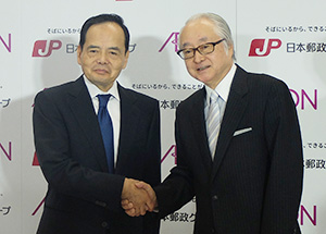 会見を終え握手するイオンの岡田元也社長（左）と日本郵政の長門正貢社長