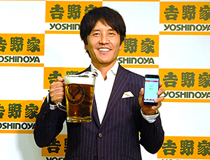 ビールとアプリを持つ河村泰貴社長