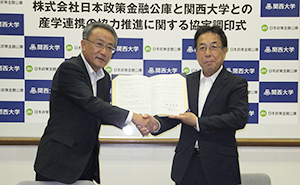 協定書へのサインを終え握手する猪塚良弘支店長（左）と楠見晴重学長