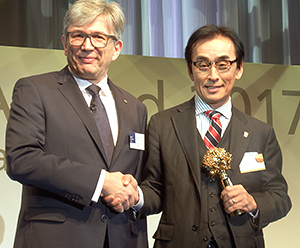 受賞トロフィーを手にする日清食品ホールディングス上村成彦CHO執行役員（右）、左はランスタッドのカイエタン・スローニナ会長・CEO