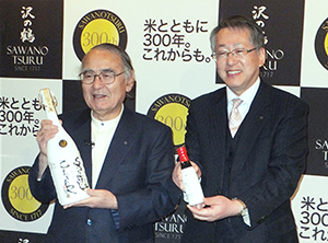 「一酒入魂」を手にする西村隆治社長（左）と、「SHUSHU」を持つ西向賞雄取締役製造部部長兼総杜氏代行