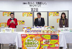 抽選会に臨む信田紀生常務取締役営業本部長（左）