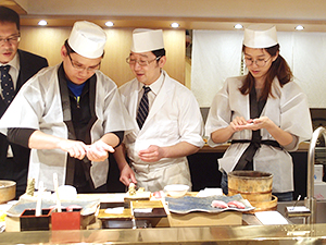 にぎり寿司に挑戦するウイルソンロー夫妻と松本ヒロシ料理長（中央）