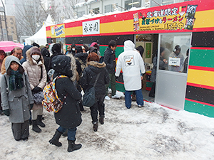 雪が降る中、試食を待つ人で行列を作る永谷園のブース