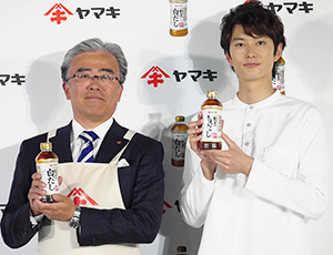 城戸善浩社長（左）とCMタレントの岡田将生。発表会はTV番組など多くのメディアを集めた