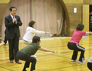 町田修一氏（左）の指導によってスクワットを行う参加者たち