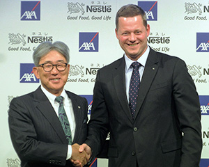 握手を交わす高岡浩三社長（左）と二ック・レーン アクサ生命保険社長兼CEO