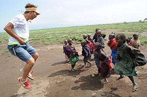 タンザニアでマサイ族の子どもたちと踊るUSAさん（C）A-Works