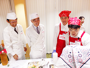 職人をイメージした装いの中村圭介専務（左端）と太田隆行専務（左から2人目）が天ぷらの揚げ方を指導