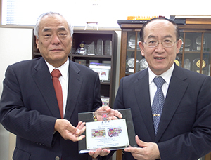 浅生貴広キョーエイ社長（右）に表彰盾を贈呈する松尾昭英明星食品社長