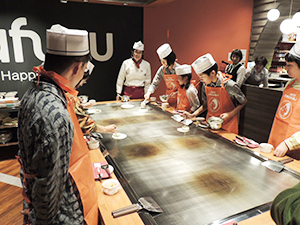 大きな鉄板を囲んで本格的なお好み焼きづくりが体験できる