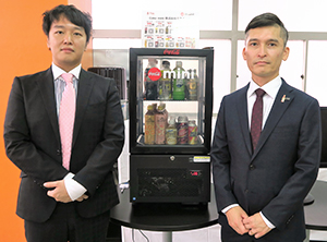 「Coke mini」を挟んで岡田侑也ミライユ代表取締役（左）と坂井憲治担当部長