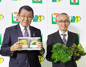 植物工場で生産のリーフレタスを使ったサラダを手にする古屋一樹セブン―イレブン・ジャパン社長（左）と齊藤正義プライムデリカ社長